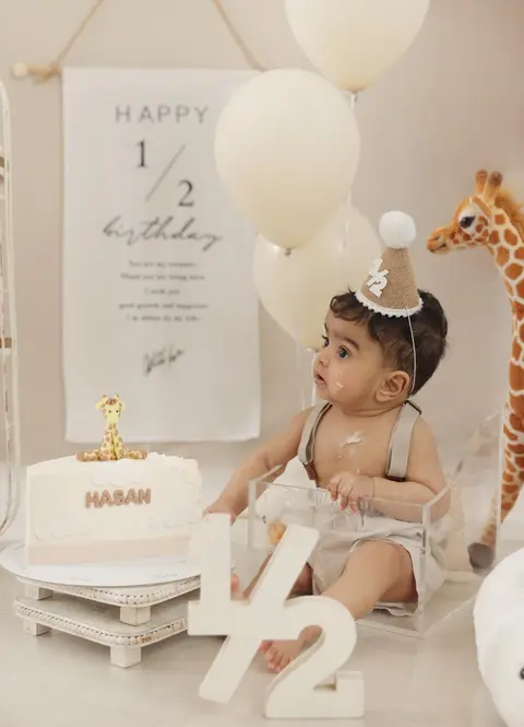 طفل مع كيكة ورقم ½ في جلسة نصف عيد الميلاد